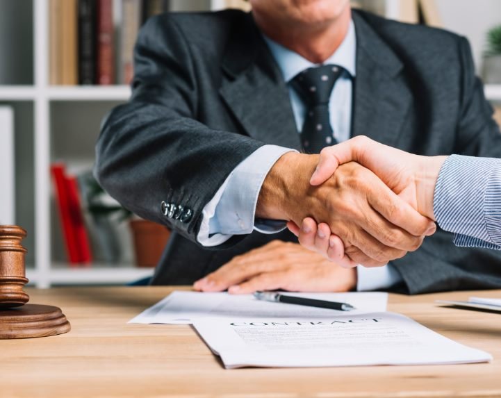 Cliente y abogado cerrando un acuerdo tras la firma de un contrato